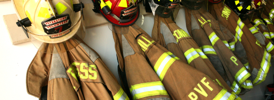 Firemen's coats and helmets hanging up.